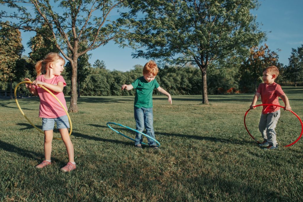 girl; boy; playing; hoola; hoop; park; sport; activity; recreation; fun; exercise; seasonal; hobby;